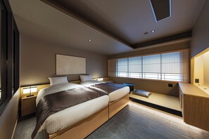 Ein modernes Schlafzimmer mit einem großen Bett, Nachttischen, einer eingebauten Bank und einem Fenster mit Jalousien.
