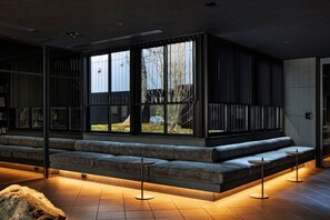 Ein modernes Interieur mit einer langen Bank, großen Fenstern und einem Steindekor.