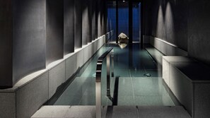 A modern, minimalist hallway with a glass-bottomed pool, leading to a blue-lit room. - Hotel tou nishinotoin kyoto (Kyoto)