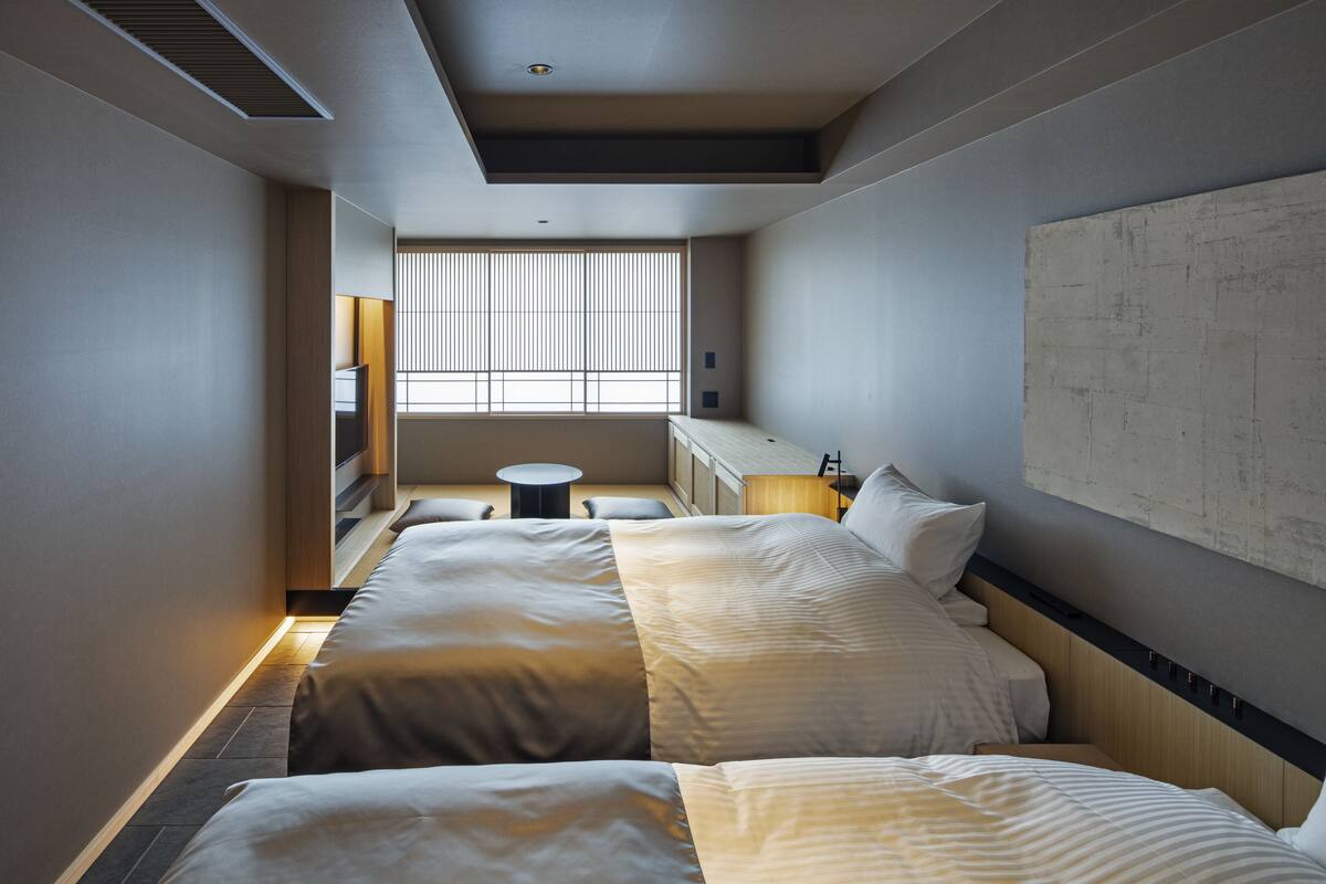 Una habitación de hotel con una cama grande, un escritorio y una ventana con persianas.