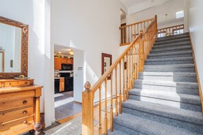 A staircase with wooden balusters and carpeted steps leading to an upper floor.