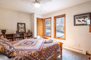 A bedroom with a large bed, a bookshelf, a window with a view, and a ceiling fan. - Timberly - 699 Ridge Road

Timberly - Private Wooded Lot, Outdoor Hot Tub, Pool Table, Pet Friendly, Lake Access! (Davis)