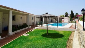 A courtyard with a swimming pool, a covered seating area, and a stone wall. - RIVIERA PLAYA 200m to the beach in Riviera del Sol (Mijas Costa)