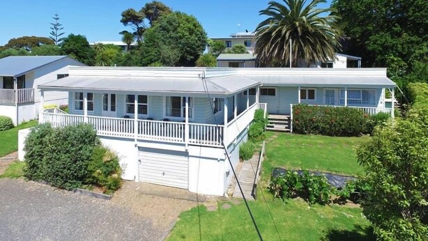 A two-story house with a covered porch and a small front yard. - House with self-contained adjoining studio. Great for large groups (Auckland)