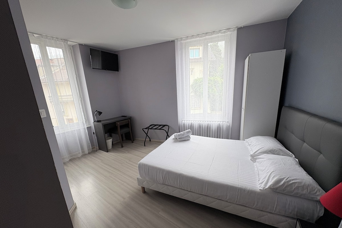 Un dormitorio moderno con cama, escritorio y silla.