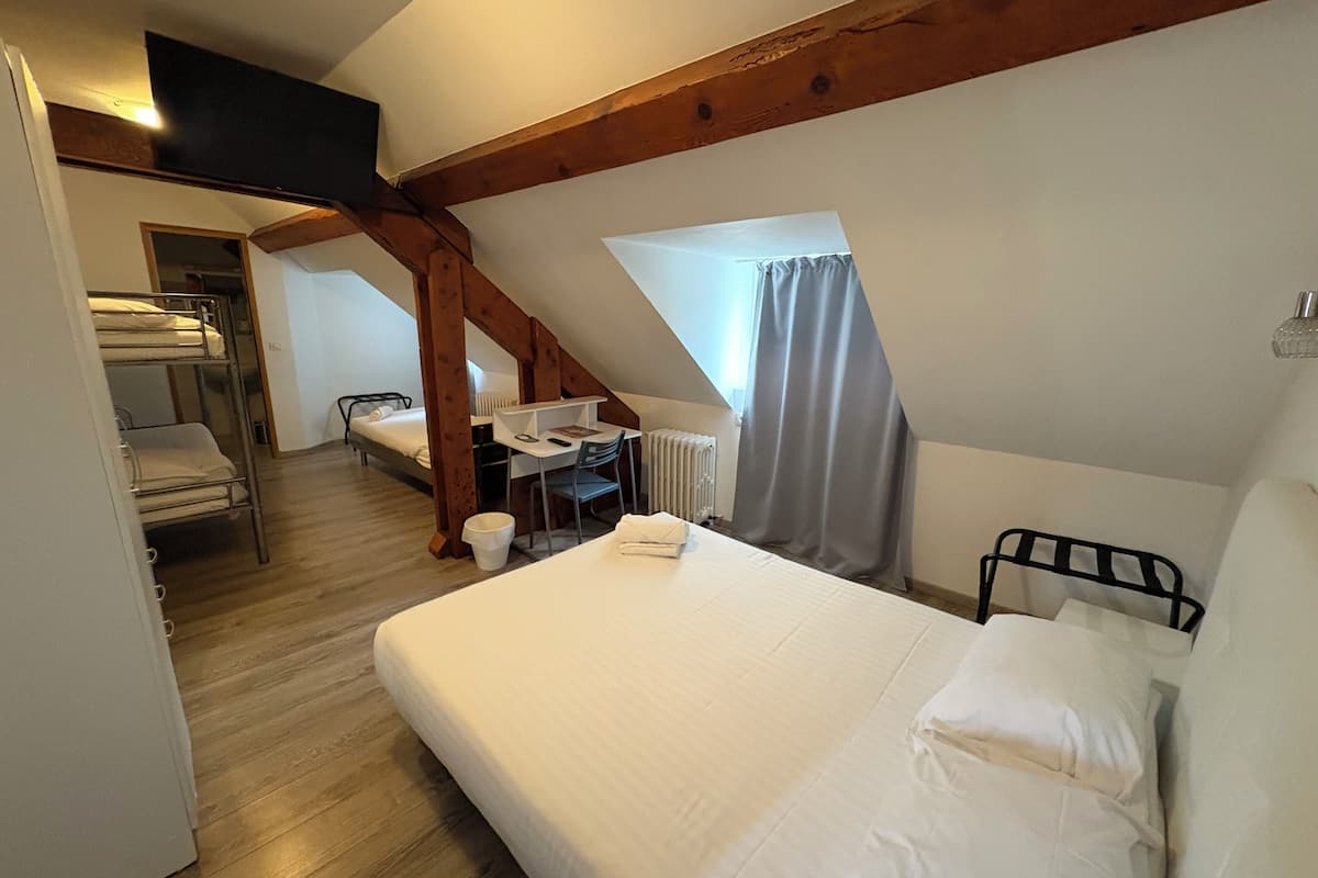 Un dormitorio con una cama individual superpuesta, un escritorio y una silla.