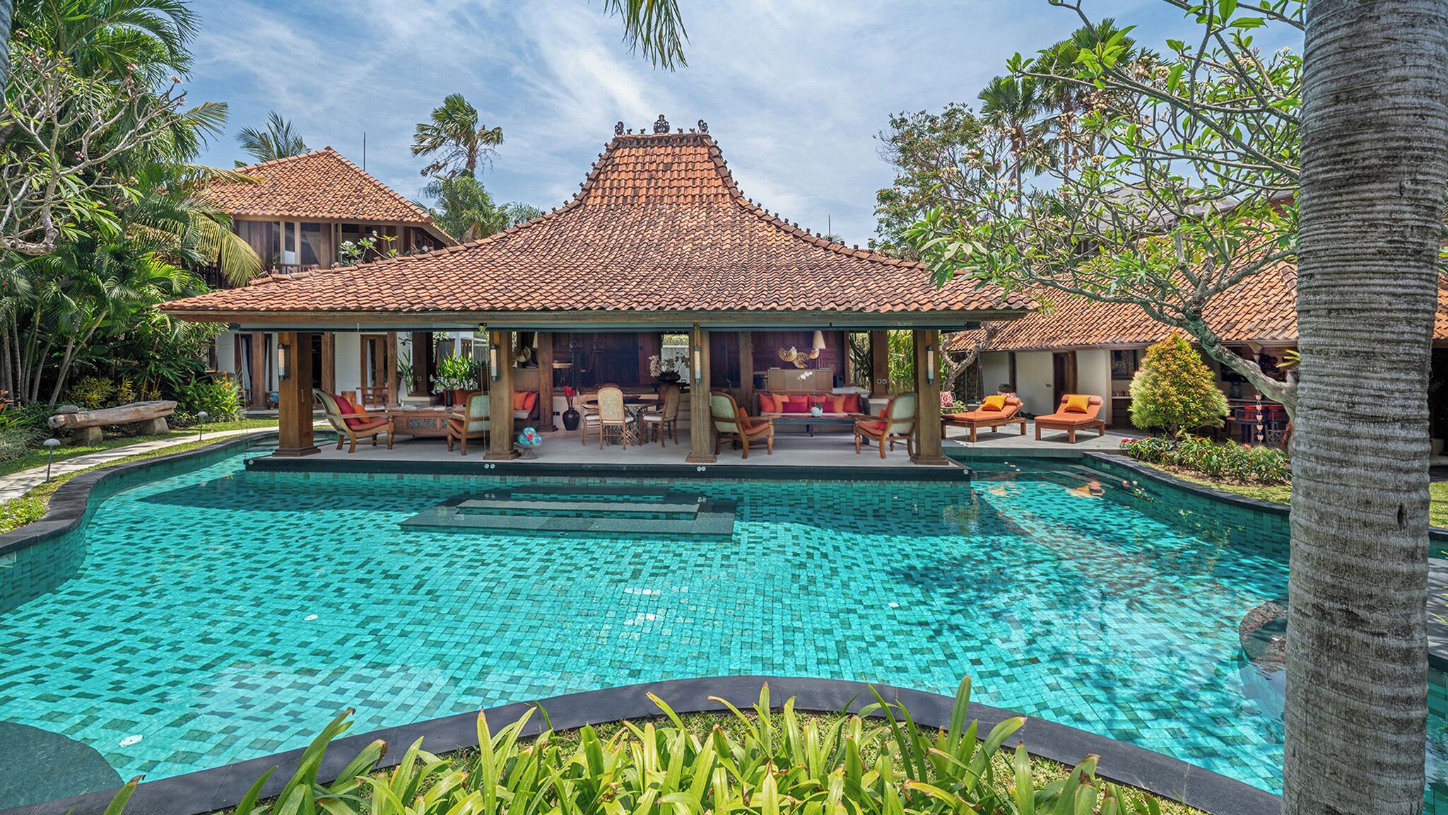Un complexe hôtelier doté d’une grande piscine, d’espaces de détente abrités et d’un aménagement paysager de style tropical.