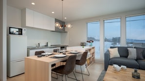 Una cucina moderna con zona pranzo, divano e vista sulla città.