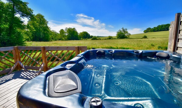 A hot tub on a wooden deck with a view of a grassy field and trees. - Chalet, Nature, Spa & Sauna 2* #2 (La Réunion)