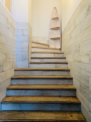 A staircase with wooden steps and a wooden shelf at the top.