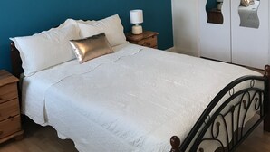 A bedroom with a bed, nightstands, a wardrobe, and a ceiling light fixture. - Remarkable 3-bed House in Ipswich With a Zen Vibe (Ipswich)