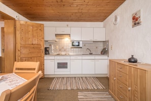 Une cuisine avec des meubles en bois, un four à micro-ondes et une cuisinière.