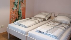 Ein Schlafzimmer mit einem Bett, einer Hängelampe und einer Wandmalerei.