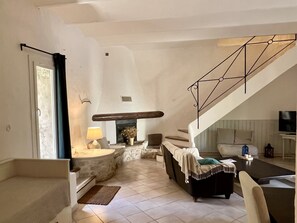 A spacious living area with a fireplace, a staircase, and a seating area.