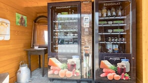 Dos vitrinas refrigeradas con la etiqueta 'REGIOMAT' que exhiben distintos alimentos y una pequeña mesa con un hervidor.