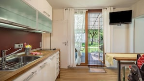 Eine moderne Küche mit Spüle, Schränken und einem Fernseher.