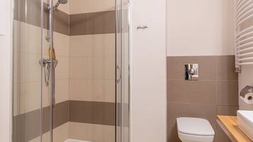 Une salle de bain moderne avec une douche à parois de verre, des toilettes et un lavabo.