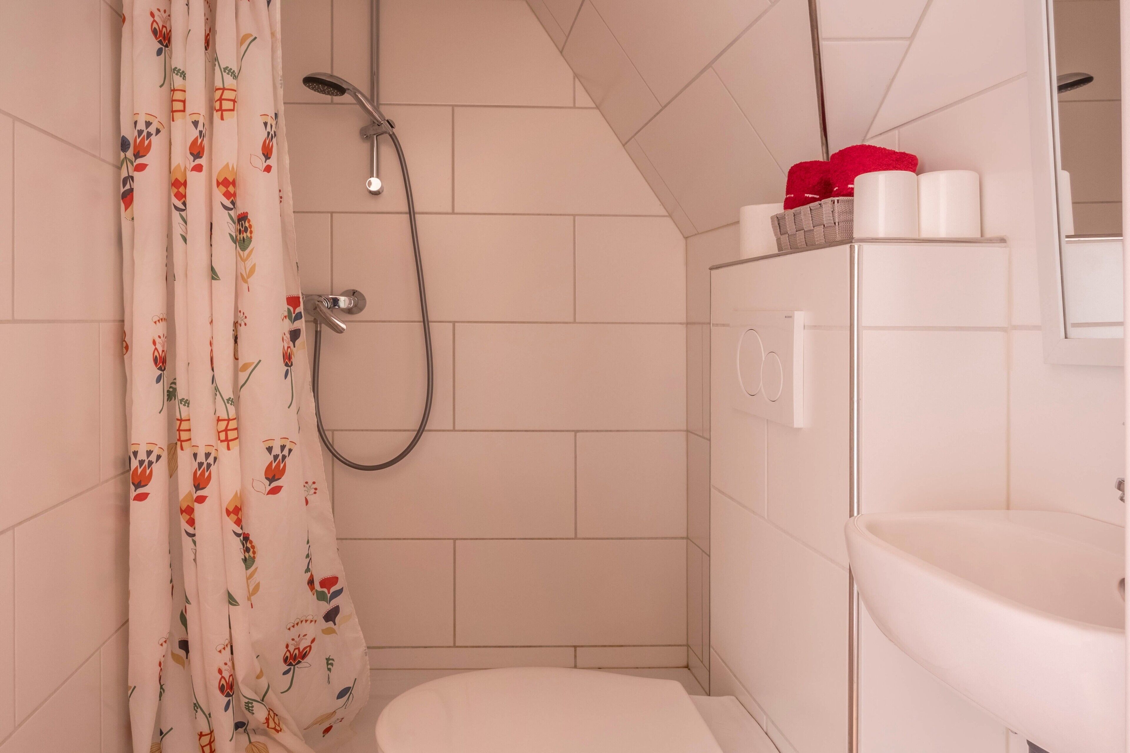 Un bagno con doccia, toilette e lavandino.