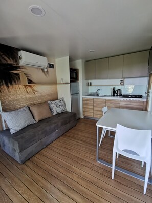 Cozy living space with a sofa, dining table, and kitchenette.