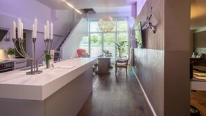A modern kitchen with a central island, a staircase, and a dining area. - Holiday Apartment "Hof zum Stadl" 1 at Lake Constance – Walk to Ravensburger Spieleland (Meckenbeuren)