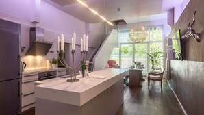 A modern kitchen with a central island, stainless steel appliances, and a staircase leading to an upper level. - Holiday Apartment "Hof zum Stadl" 1 at Lake Constance – Walk to Ravensburger Spieleland (Meckenbeuren)