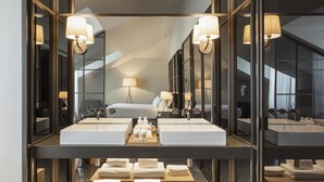 A modern hotel room with a large mirror, two sinks, a bed, and a tray of towels. - Casa da Companhia Hotel & Spa, Vignette Collection by IHG (Porto)