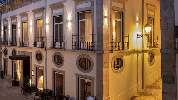 A building with multiple balconies, round windows, and outdoor seating areas. - Casa da Companhia Hotel & Spa, Vignette Collection by IHG (Porto)