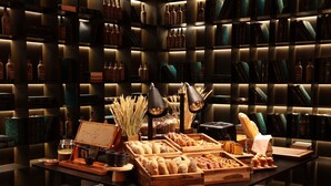 A bakery display with pastries and bread, surrounded by shelves of books and bottles. - Casa da Companhia Hotel & Spa, Vignette Collection by IHG (Porto)