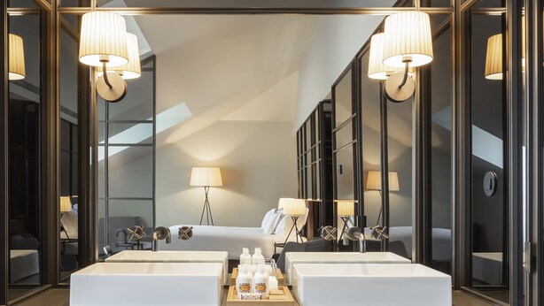 A modern bathroom with two sinks, a vanity, and a mirror. There are towels and toiletries on the vanity. - Casa da Companhia Hotel & Spa, Vignette Collection by IHG (Porto)
