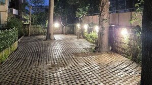 A paved courtyard with trees and a building in the background. - Relais Villa Montedonzelli (Naples)