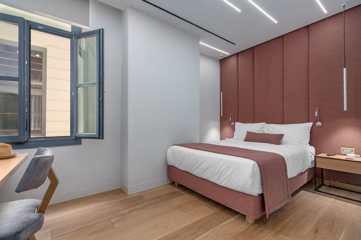 A modern bedroom with a bed, a desk, and a chair.