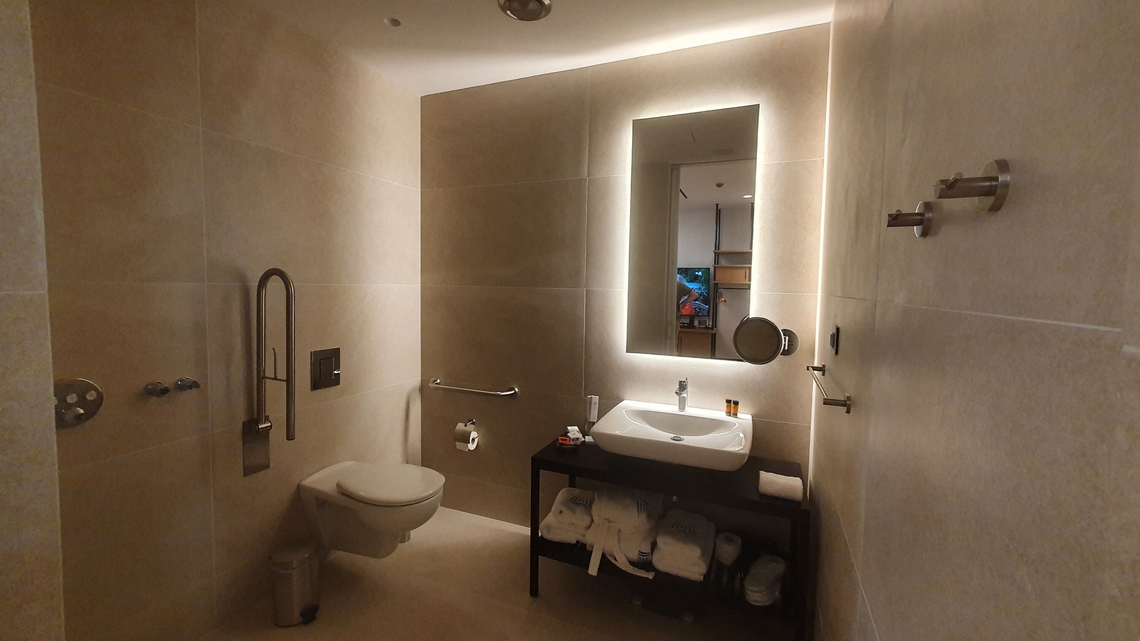 A modern bathroom with a toilet, sink, and shower.