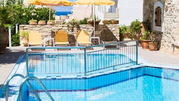 Piscina a l'aire lliure de temporada, para-sols i gandules