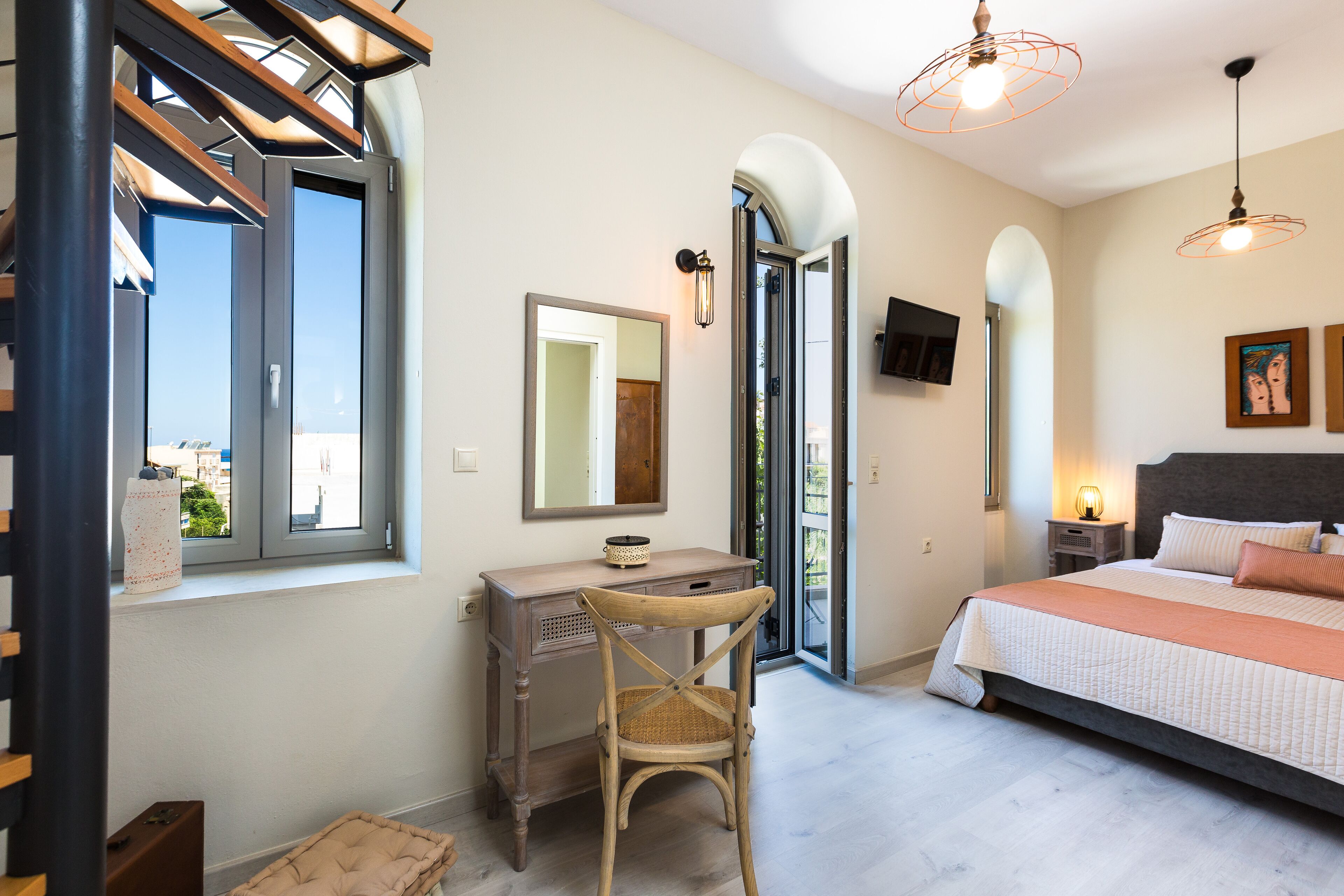 Un dormitorio con cama, escritorio, silla, televisión y ventana con vistas.