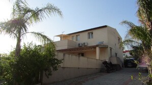 Un bâtiment à deux étages, doté d’un toit plat, de climatiseurs et d’une antenne parabolique.