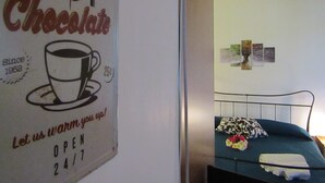 Une enseigne pour un café-chocolaterie, avec une tasse et une soucoupe, un prix de 25 cents et un message indiquant : « Laissez-nous vous réchauffer ! ».