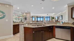 A spacious kitchen with granite countertops, stainless steel appliances, and a large island with a sink. - 5th Floor!!  Oasis, Formerly West II, New Owner, New to the Rental Market! (Orange Beach)