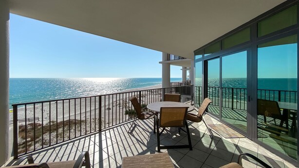 A balcony with a table and chairs, overlooking a beach and the ocean. - 5th Floor!!  Oasis, Formerly West II, New Owner, New to the Rental Market! (Orange Beach)