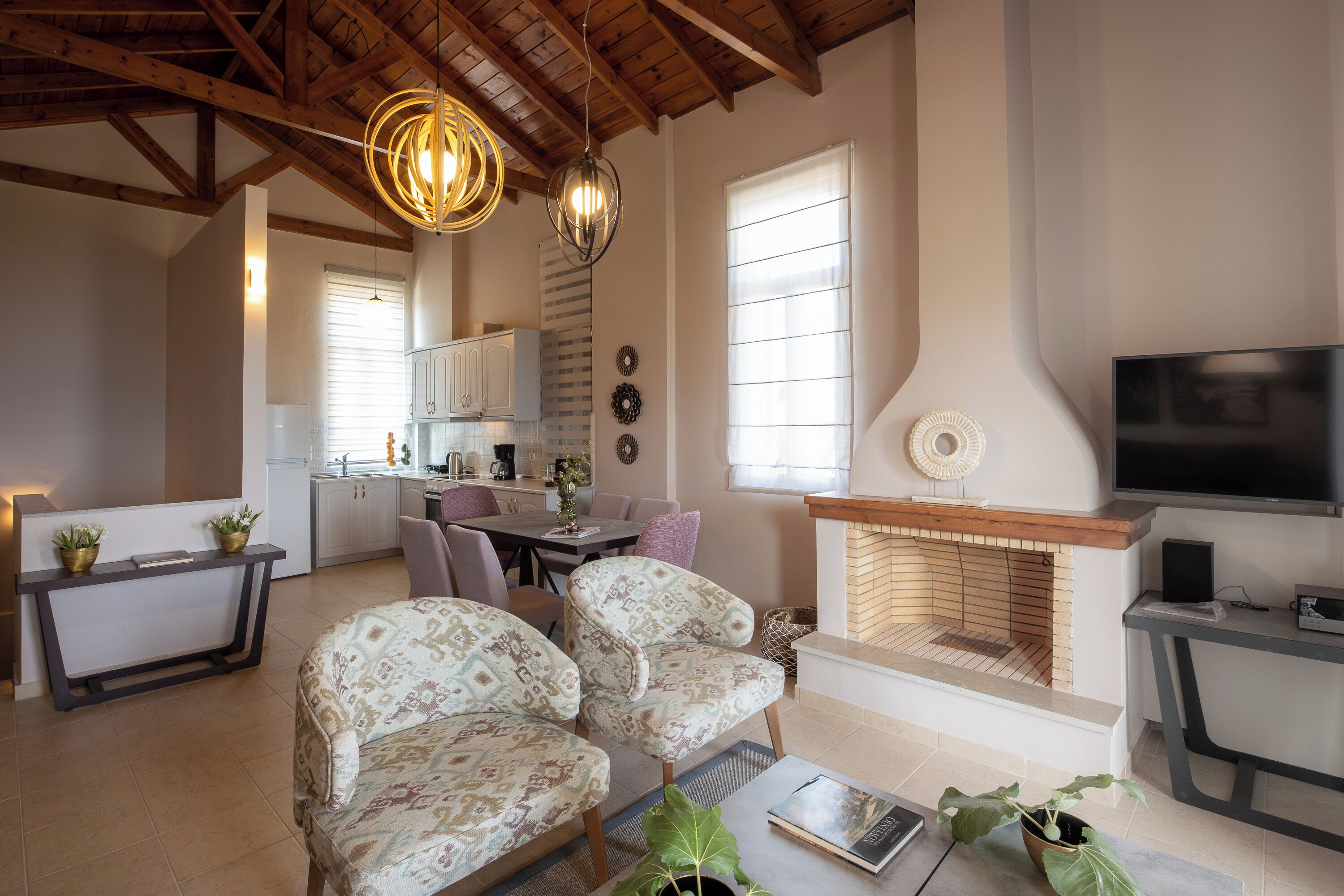 A spacious living room with a fireplace, a dining area, and a kitchen.