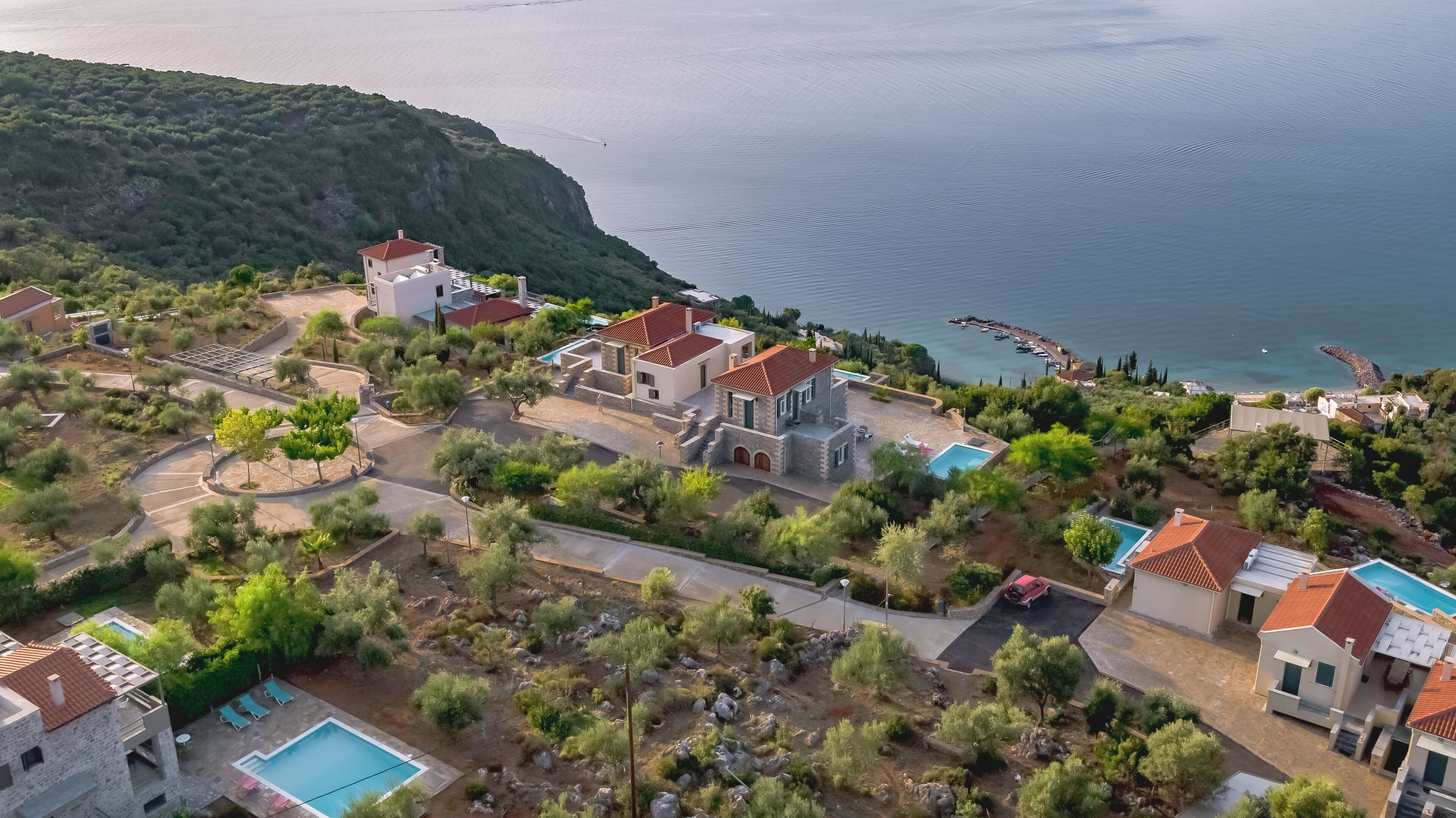 Un quartier résidentiel situé sur la côte, avec des maisons, une piscine et un port de plaisance.