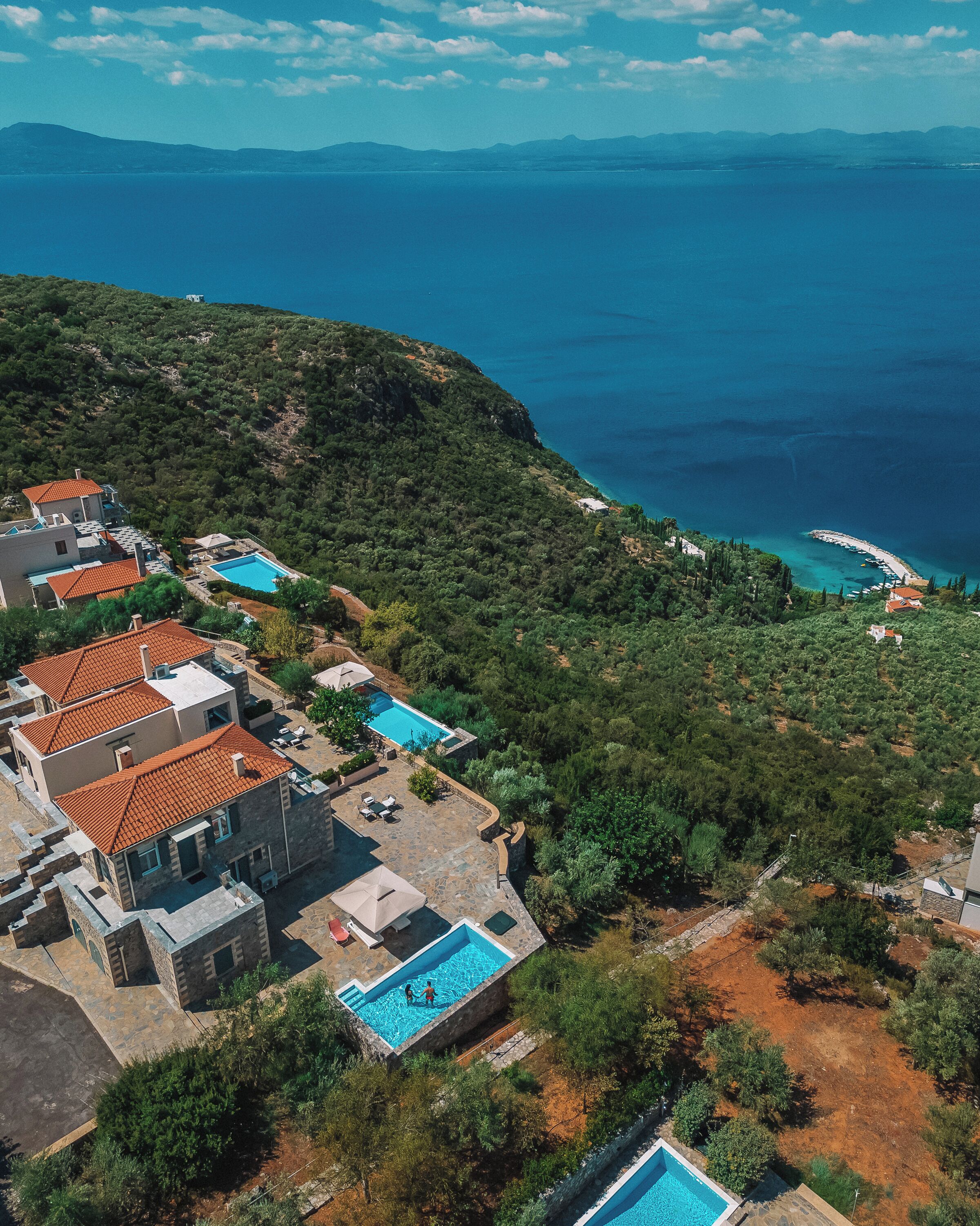 Ein Küsteneigentum mit mehreren Schwimmbecken, Reihenhäusern und Meerblick.