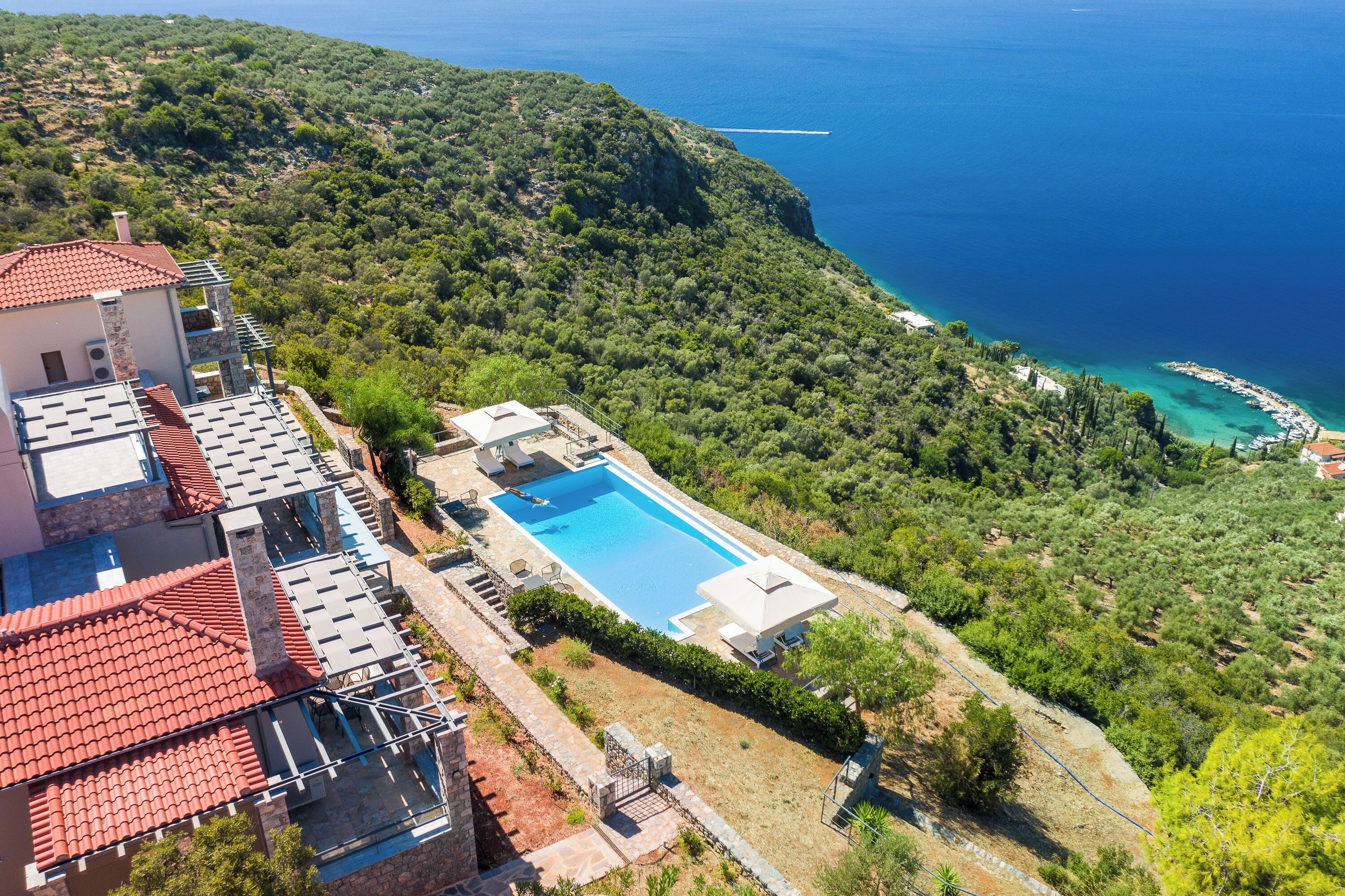A villa with a swimming pool, terraced garden, and a view of the sea.