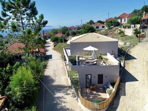 A modern two-story house with a patio, a view of the sea, and a hilly neighborhood. - Elsa Modern Apartment One bed with private outdoor seating. Ground level Apt1 (Pogonia)