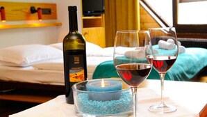 A hotel room with a bed, a bottle of wine, two wine glasses, and a candle on a bedside table. - Wonderful apartment inside the top residence kurz (Maso Corto)