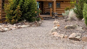 A log cabin with a prominent porch, a chimney, and a gravel driveway. - Arrowhead Lodge -Secluded home with incredible views and now Air Conditioning (Livingston)