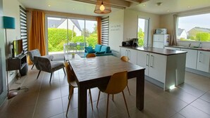 A modern kitchen with a dining area, large windows, and a view of greenery outside. - House La Houle Erquy *Pool* *Beach at 800m* (Erquy)