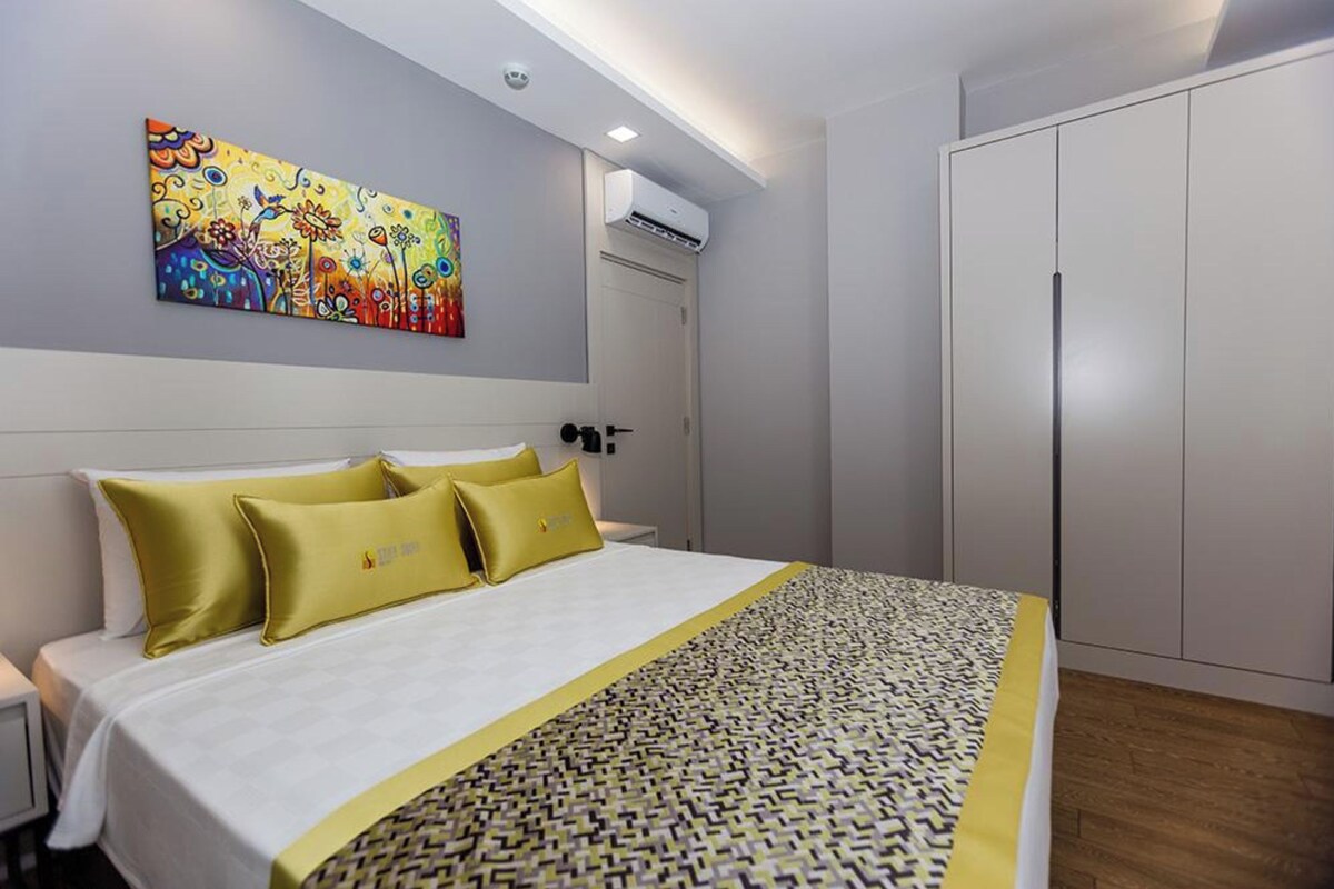 Habitación de hotel con cama, un cuadro en la pared, aire acondicionado y armario.