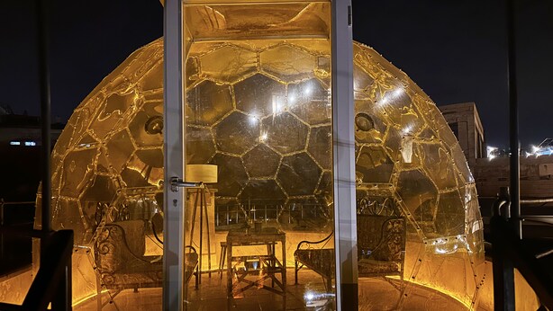 A spherical glass structure with a hexagonal pattern, a door, and a small table with chairs inside. - Cappadocia Balloon Cave (Nevsehir)