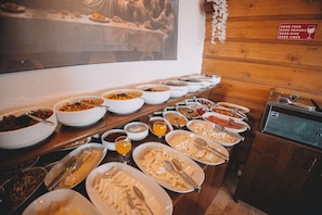 A buffet with various food items and a sign on the wall. - Balloon Cave Hotel (Nevsehir)