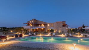 A stone villa with a swimming pool, outdoor seating, and ambient lighting. - Abeloessa Methonian Hospitality (Pylos-Nestoras)